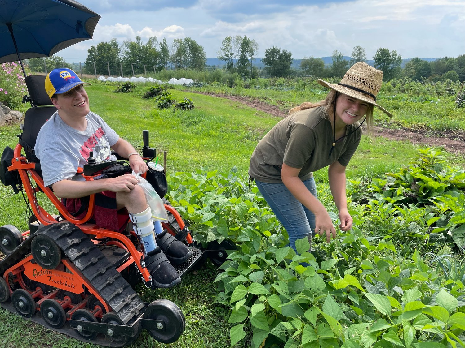 Volunteer Jay harvests beans with Carly, the farm/horticulture assistant.